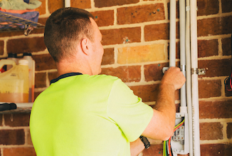 An electrician working on a conduit